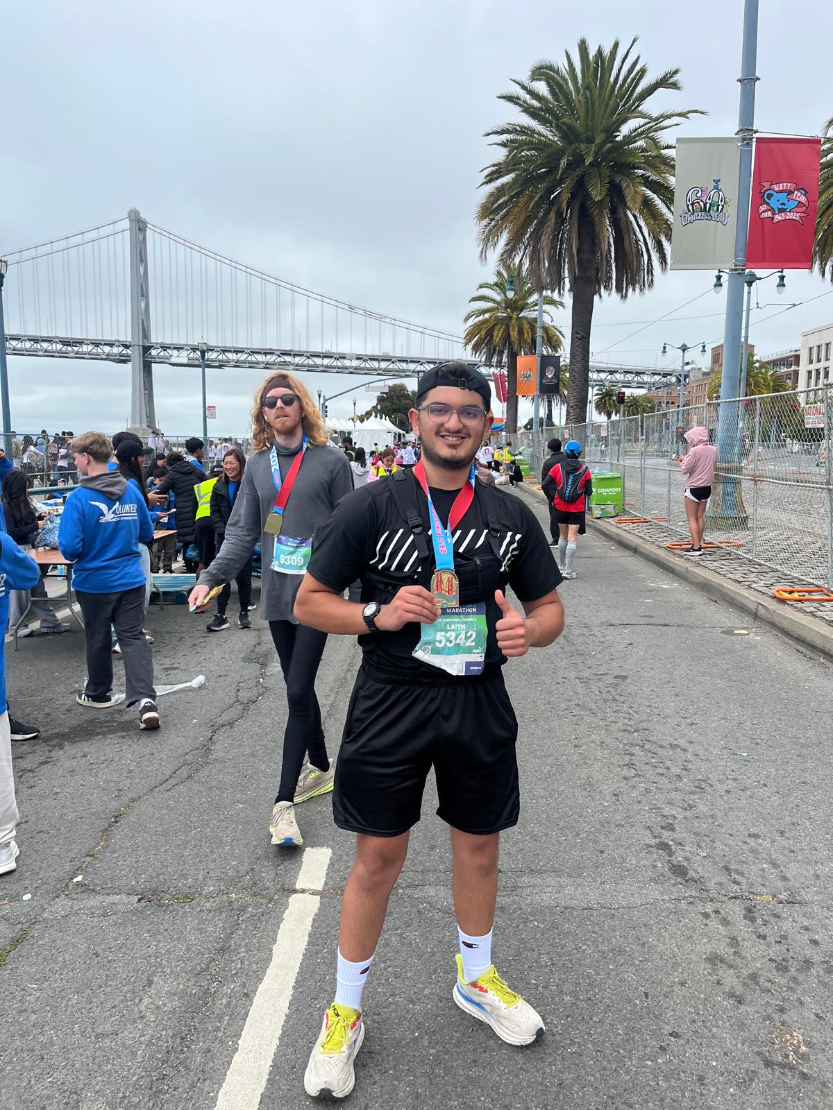 Laith celebrating with marathon medal and race bib